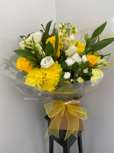 Golden Glow Hand-Tied - A radiant hand-tied bouquet designed to bring warmth and happiness to any occasion. With its fresh, uplifting colour palette and natural greenery, this arrangement creates a vibrant yet balanced look, beautifully finished with elegant wrapping and a soft ribbon.

Perfect for celebrations, thank you gifts, or simply brightening someone’s day, this bouquet is a joyful choice that makes an instant impression.