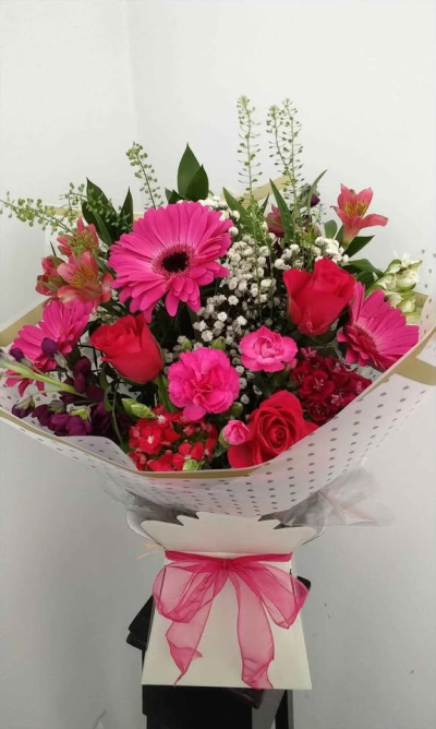 Blushing Beauty - A vibrant and eye-catching hand-tied bouquet filled with rich pink tones and fresh greenery, creating a lively and uplifting display. Beautifully wrapped in stylish packaging and finished with a soft ribbon, this arrangement offers a perfect balance of charm and elegance.

Ideal for birthdays, celebrations, or simply showing someone you care, this bouquet is designed to bring joy, warmth, and a touch of romance to any occasion.