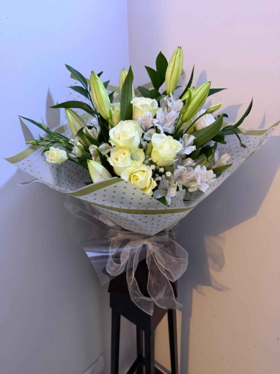 Pure Elegance Hand-Tied - A beautifully refined hand-tied bouquet featuring soft, neutral tones and fresh greenery for a timeless and sophisticated look. Wrapped in delicate, understated packaging and finished with a flowing ribbon, this arrangement offers a sense of calm and graceful simplicity.

Perfect for weddings, sympathy occasions, or elegant gifting, this bouquet is designed to bring a touch of serenity and classic beauty to any setting.